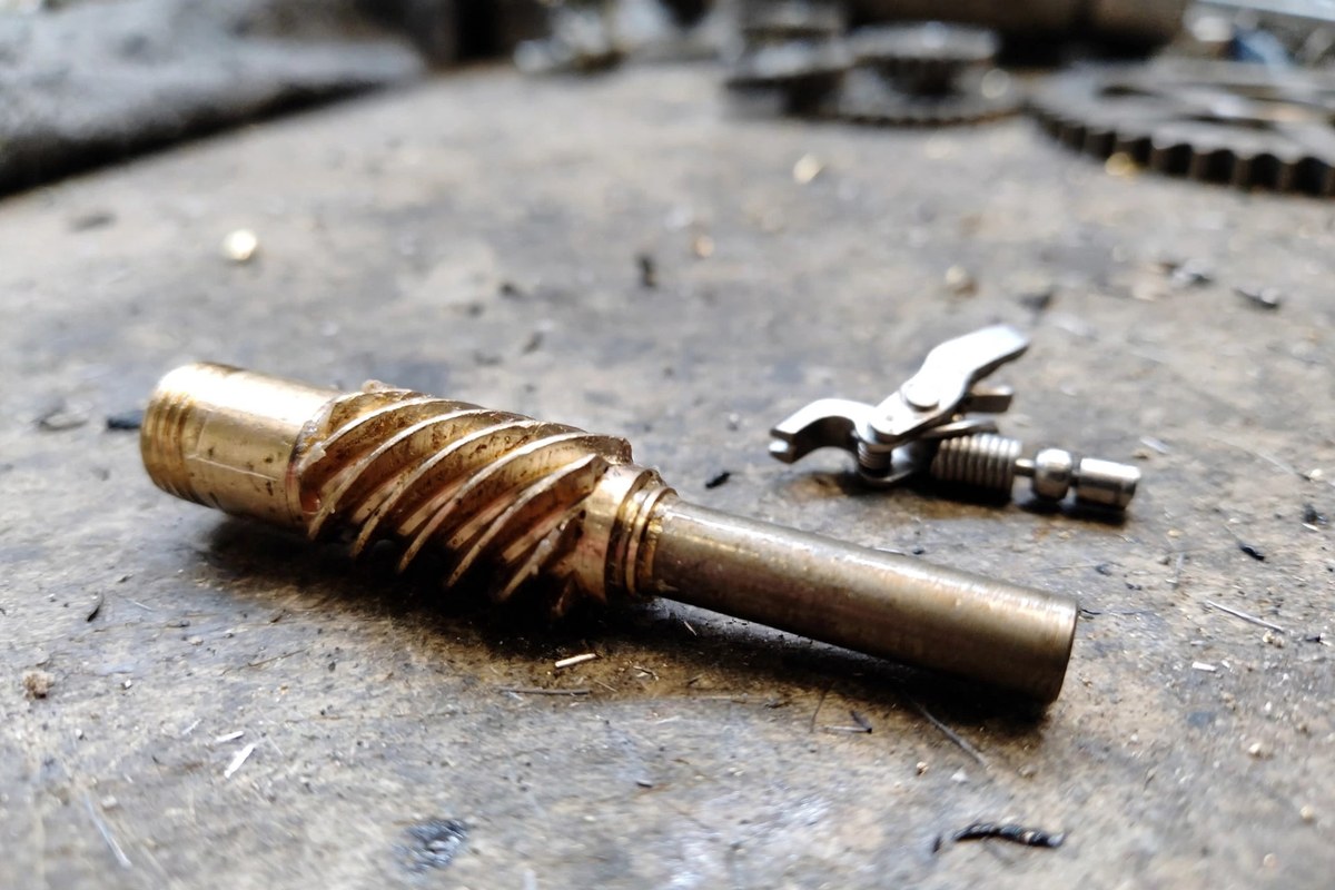 Close-up of a baitcaster worm gear and the line guide pawl that rides in its grooves